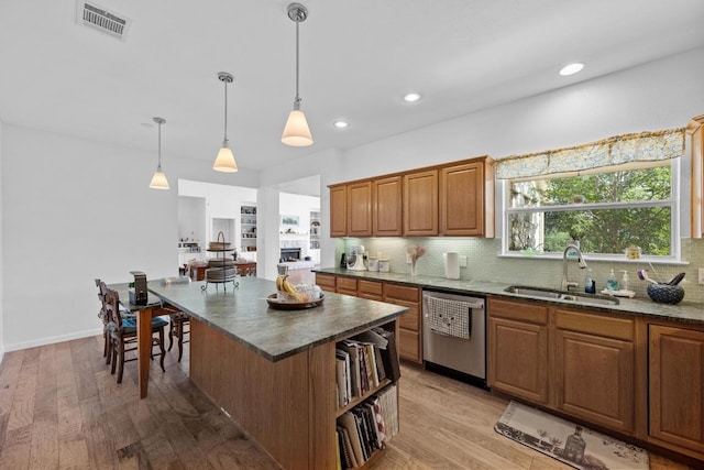 10978 W Cave Blvd, Dripping Springs, TX 78620 - kitchen featuring dishwasher, a sink, tasteful backsplash, light wood finished floors, and pendant lighting