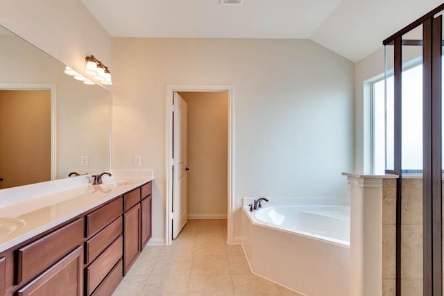 full bathroom with a bath, tile patterned floors, lofted ceiling, and double vanity