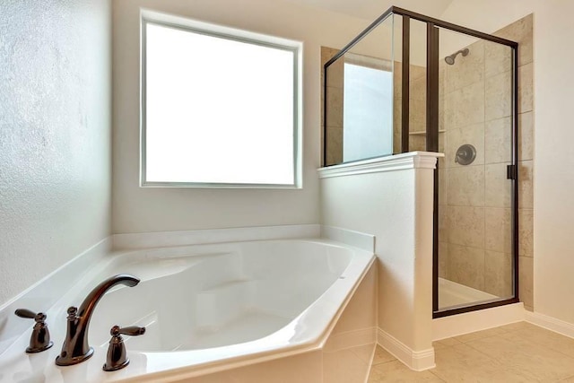 bathroom with a shower stall, a garden tub, and tile patterned flooring