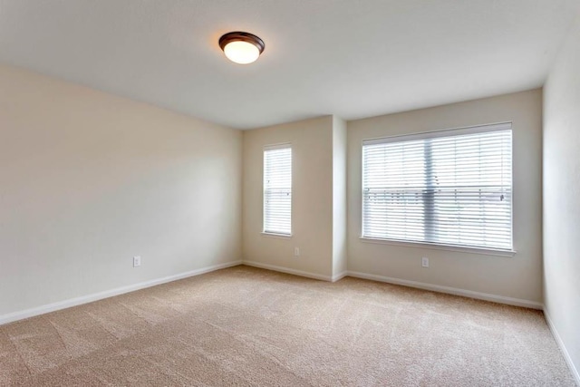 carpeted spare room featuring baseboards