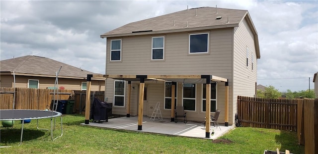 rear view of property with a trampoline and a patio