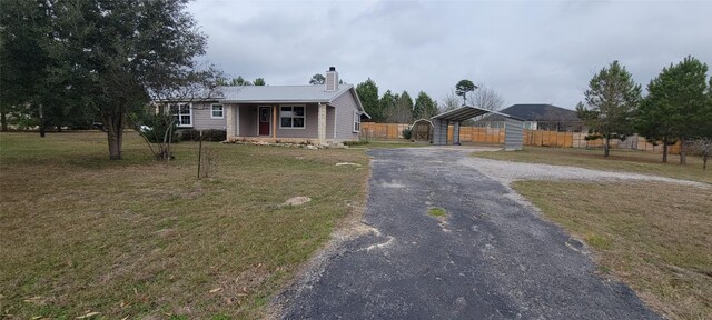 195 Cardinal Dr, Paige, TX 78659 - view of front of property featuring driveway, a chimney, a detached carport, and a gate