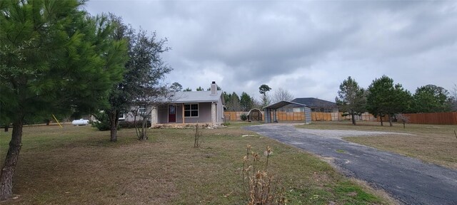 195 Cardinal Dr, Paige, TX 78659 - view of front of home with asphalt driveway, a chimney, a carport, and a porch