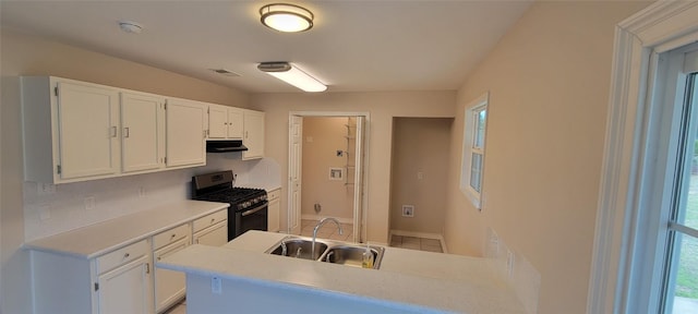 195 Cardinal Dr, Paige, TX 78659 - kitchen featuring stainless steel range with gas stovetop, under cabinet range hood, a sink, and white cabinetry
