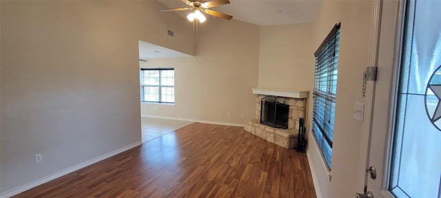 195 Cardinal Dr, Paige, TX 78659 - unfurnished living room with a fireplace, ceiling fan, wood finished floors, baseboards, and vaulted ceiling