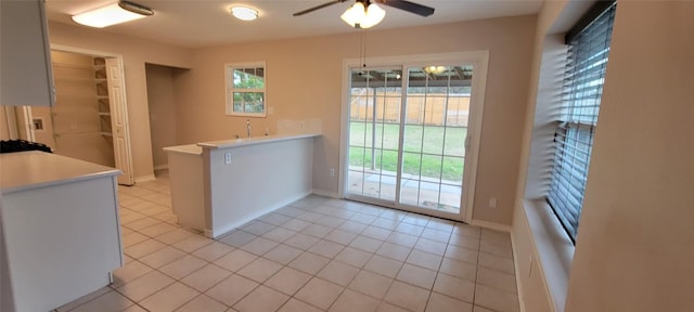 195 Cardinal Dr, Paige, TX 78659 - kitchen featuring light countertops, ceiling fan, a peninsula, and light tile patterned floors