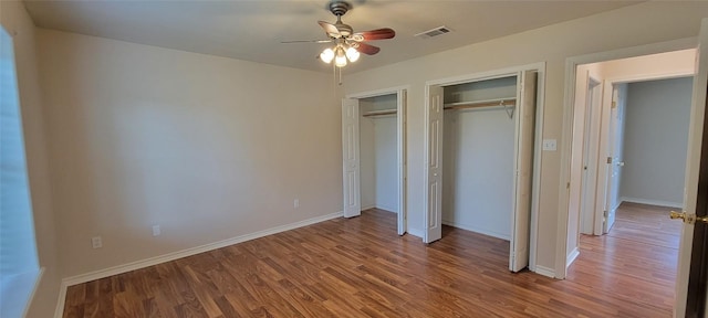 195 Cardinal Dr, Paige, TX 78659 - unfurnished bedroom with multiple closets, wood finished floors, and baseboards