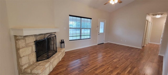 195 Cardinal Dr, Paige, TX 78659 - unfurnished living room with wood finished floors, ceiling fan, lofted ceiling, a stone fireplace, and baseboards