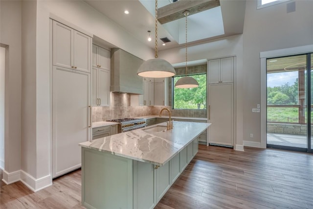 106 Edwards Cir, Horseshoe Bay, TX 78657 - kitchen featuring wall chimney exhaust hood, a sink, baseboards, range with two ovens, and healthy amount of natural light