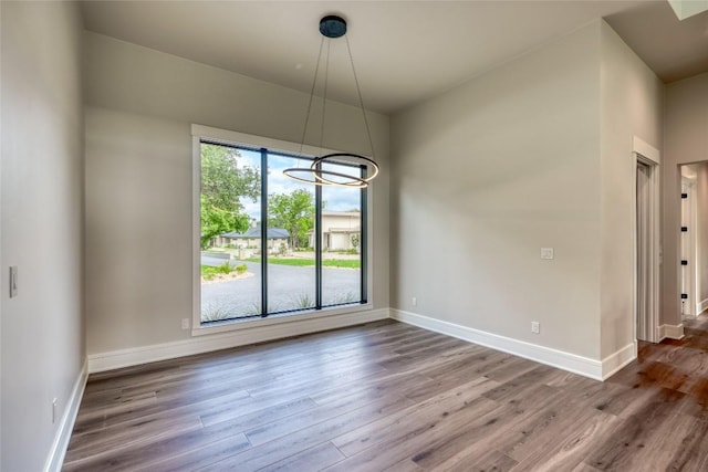 106 Edwards Cir, Horseshoe Bay, TX 78657 - unfurnished dining area featuring wood finished floors, baseboards, and a chandelier