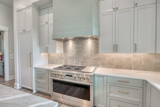 106 Edwards Cir, Horseshoe Bay, TX 78657 - kitchen with stainless steel range, custom range hood, light wood-type flooring, and decorative backsplash