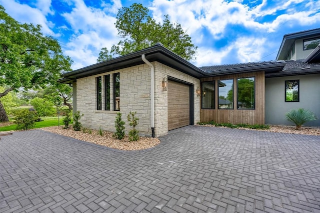 106 Edwards Cir, Horseshoe Bay, TX 78657 - view of home's exterior with a garage, decorative driveway, and stone siding