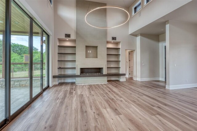 106 Edwards Cir, Horseshoe Bay, TX 78657 - unfurnished living room featuring a high ceiling, baseboards, built in features, and wood finished floors