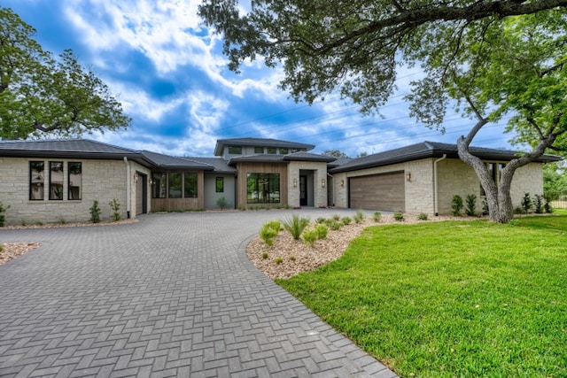 106 Edwards Cir, Horseshoe Bay, TX 78657 - prairie-style house featuring an attached garage, decorative driveway, a front lawn, and stone siding