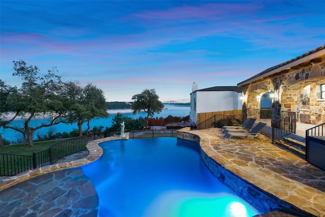 view of swimming pool featuring a patio, fence, and a water view