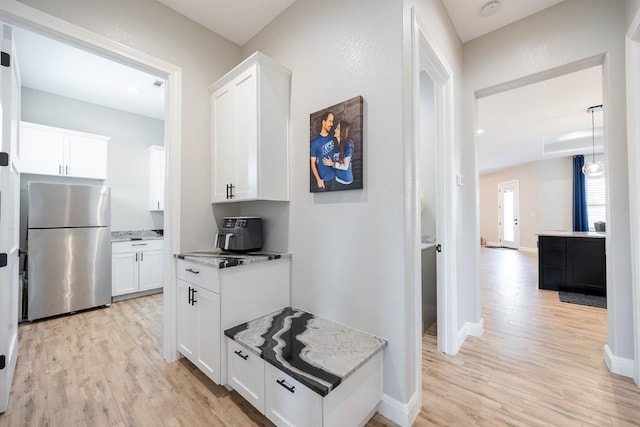 corridor with light wood-style floors and baseboards