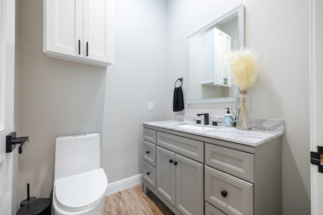 half bathroom featuring vanity and wood finished floors