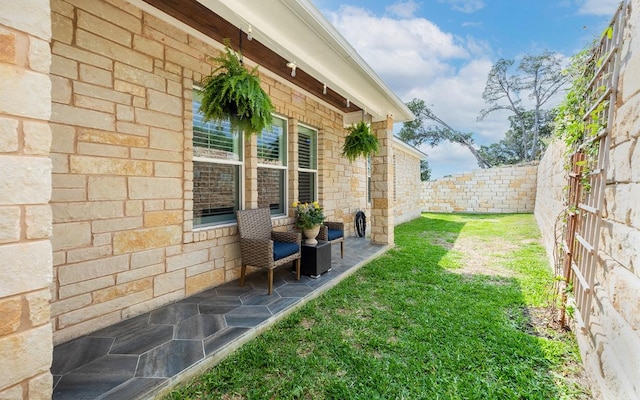 view of side of home featuring a patio and stone siding