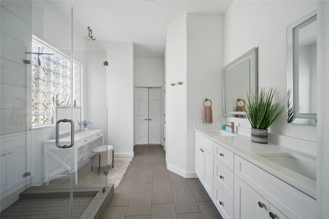 10725 Maelin Dr, Austin, TX 78739 - bathroom featuring a stall shower, double vanity, baseboards, and wood finished floors
