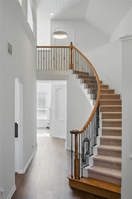 10725 Maelin Dr, Austin, TX 78739 - stairs featuring high vaulted ceiling, wood finished floors, baseboards, and arched walkways