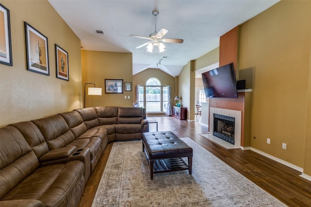 6614 Bramber Ln, Austin, TX 78754 - living area featuring ceiling fan, wood finished floors, lofted ceiling, a tile fireplace, and baseboards
