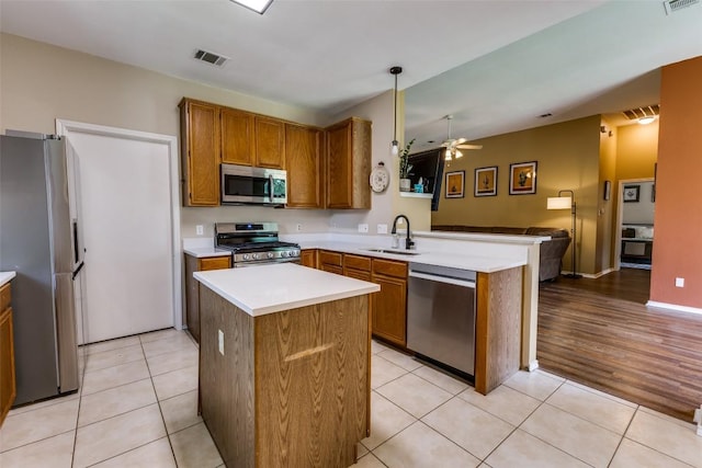 6614 Bramber Ln, Austin, TX 78754 - kitchen with appliances with stainless steel finishes, a sink, ceiling fan, a peninsula, and light countertops