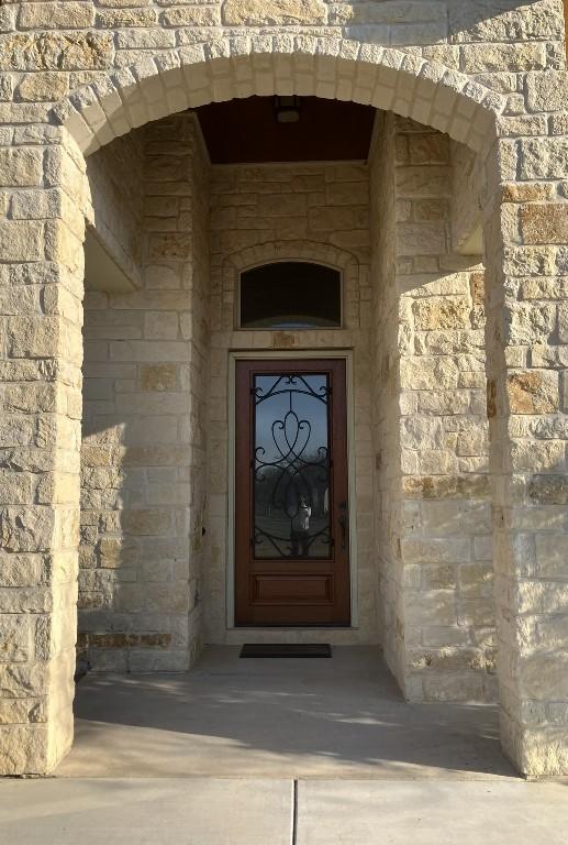 129 S Abrego Xing, Floresville, TX 78114 - doorway to property featuring stone siding