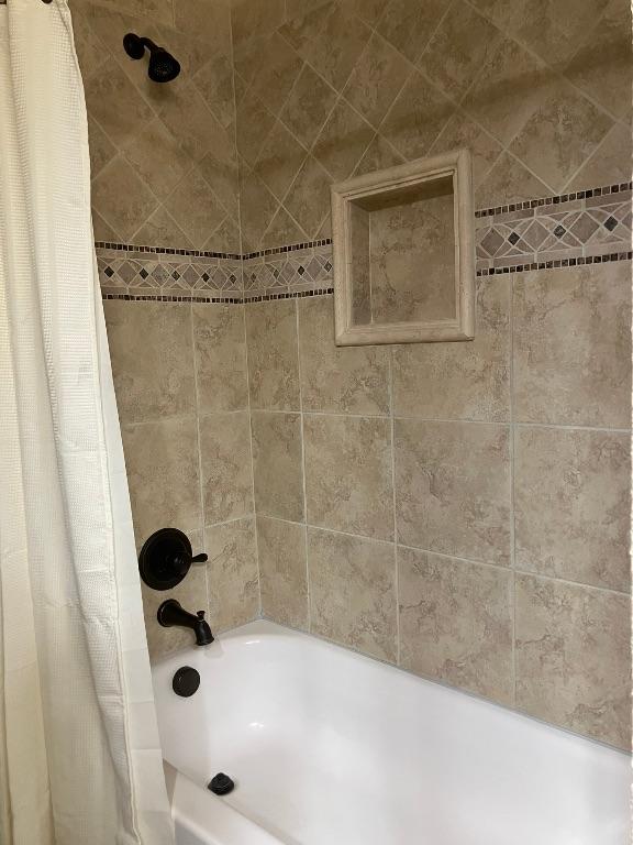 129 S Abrego Xing, Floresville, TX 78114 - bathroom featuring shower / bath combination with curtain