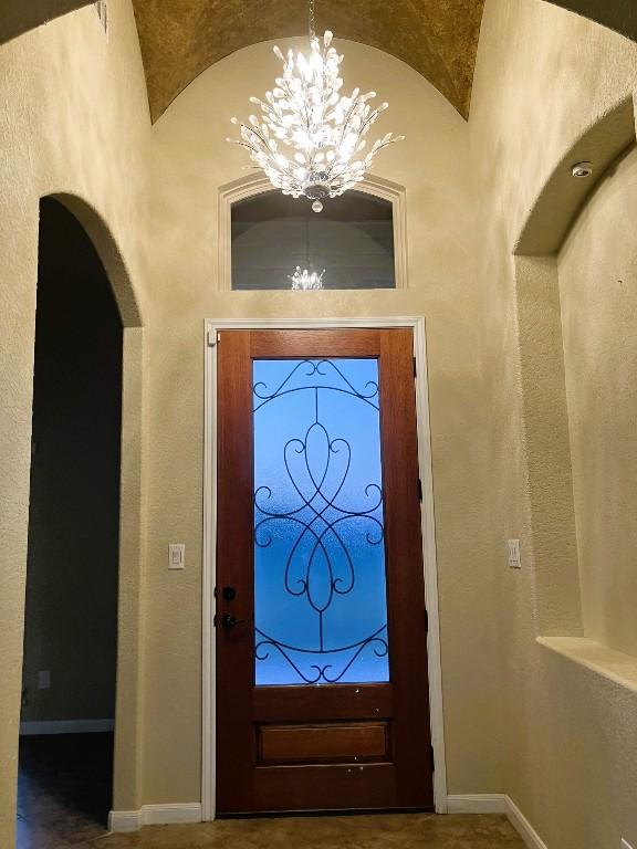 129 S Abrego Xing, Floresville, TX 78114 - entryway featuring a chandelier, arched walkways, and baseboards
