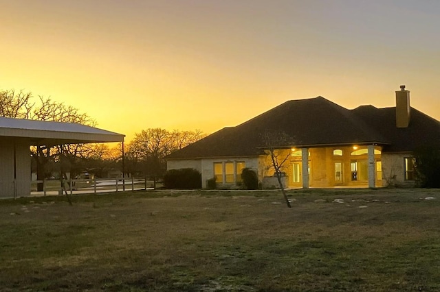 129 S Abrego Xing, Floresville, TX 78114 - back of property at dusk with a chimney