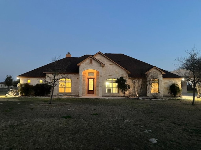 129 S Abrego Xing, Floresville, TX 78114 - french country style house with stone siding and a chimney