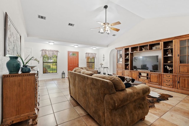living room featuring a ceiling fan, arched walkways, light tile patterned floors, and high vaulted ceiling