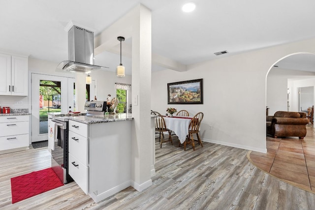 kitchen featuring electric range, island range hood, arched walkways, and light wood-type flooring