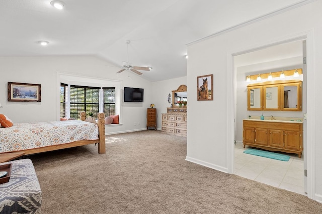 bedroom with light colored carpet, vaulted ceiling, baseboards, and ensuite bath