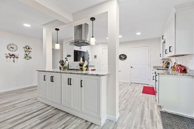 969 N State Highway 95, Bastrop, TX 78602 - kitchen with light wood-type flooring, white cabinetry, island range hood, light stone countertops, and recessed lighting