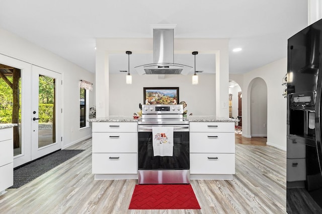 kitchen with stainless steel electric stove, island exhaust hood, arched walkways, light wood-style floors, and white cabinets
