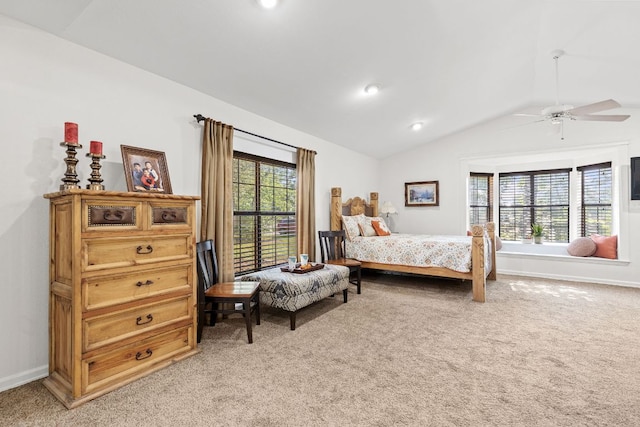 bedroom with light colored carpet, lofted ceiling, multiple windows, baseboards, and ceiling fan