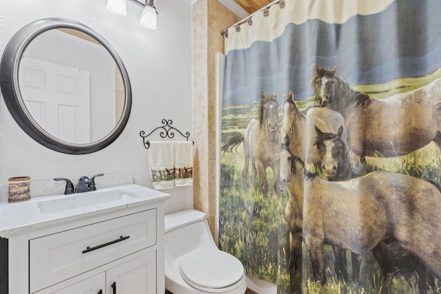 bathroom with toilet, vanity, a shower with curtain, and a textured wall