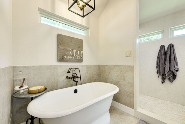 1305 Quail Ravine, Round Rock, TX 78664 - full bathroom featuring tile walls, a soaking tub, wainscoting, and a walk in shower