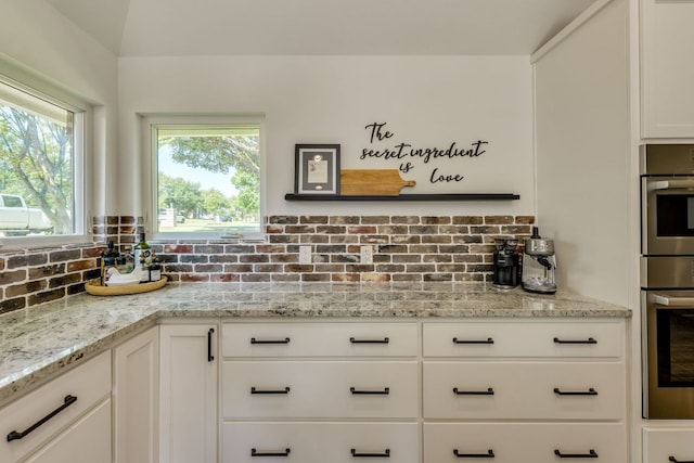 1305 Quail Ravine, Round Rock, TX 78664 - kitchen with oven, backsplash, white cabinetry, and light stone countertops
