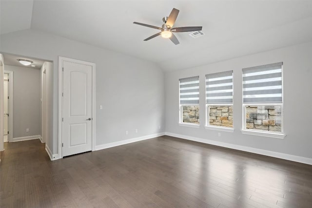 empty room featuring vaulted ceiling, a ceiling fan, dark wood-style floors, and baseboards