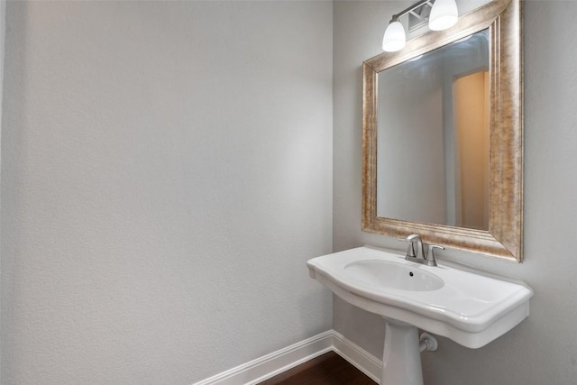 bathroom with baseboards and wood finished floors