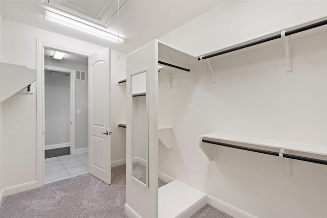spacious closet featuring light colored carpet