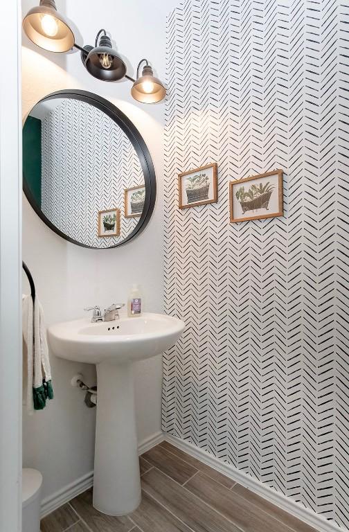 500 Pickrell Loop, Liberty Hill, TX 78642 - bathroom with baseboards, toilet, a sink, and wood finish floors