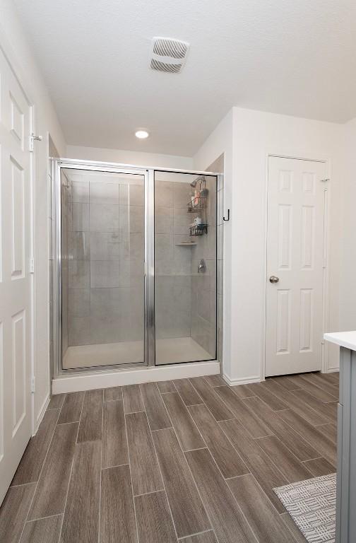 500 Pickrell Loop, Liberty Hill, TX 78642 - full bathroom with wood finish floors, a shower stall, and recessed lighting