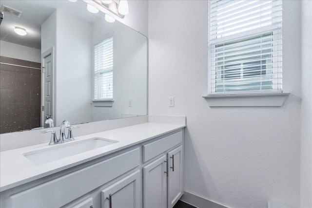 full bath featuring vanity and a tile shower