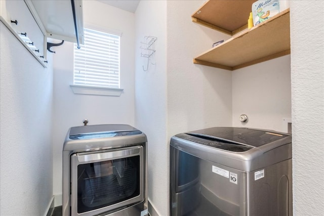 clothes washing area with washer and clothes dryer