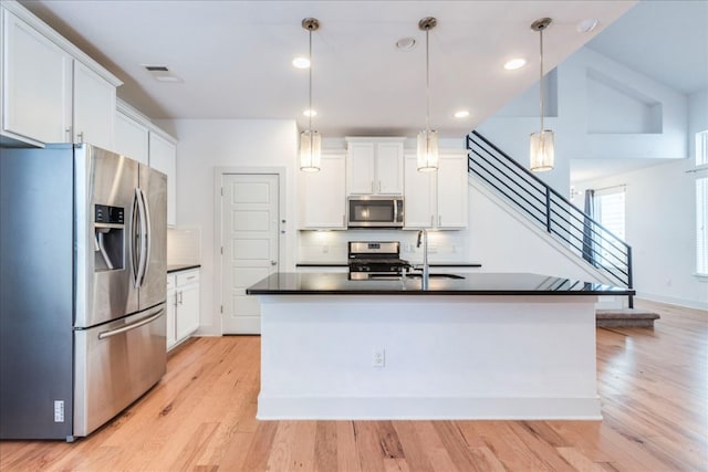 kitchen featuring stainless steel appliances, dark countertops, a sink, decorative backsplash, and recessed lighting