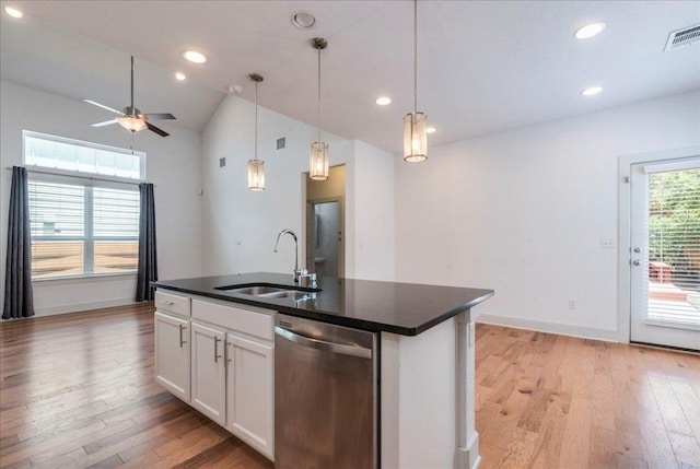 kitchen featuring stainless steel dishwasher, a sink, dark countertops, light wood-style floors, and recessed lighting