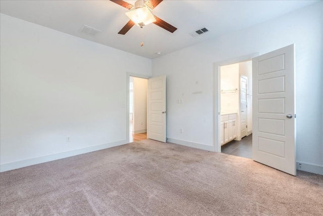 unfurnished bedroom with carpet flooring, baseboards, connected bathroom, and a ceiling fan